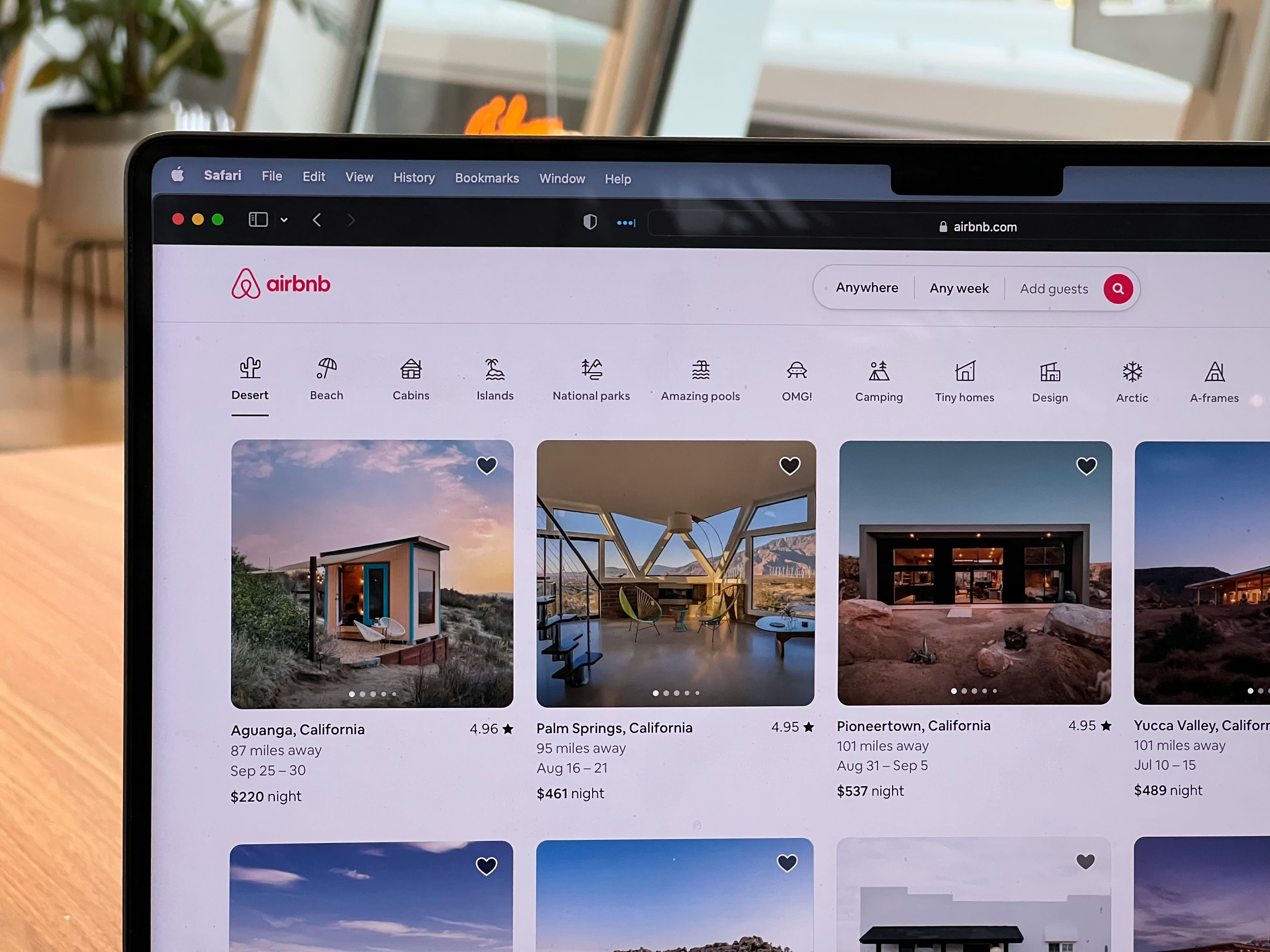 Airbnb website open on a laptop, showing vacation-stay listings